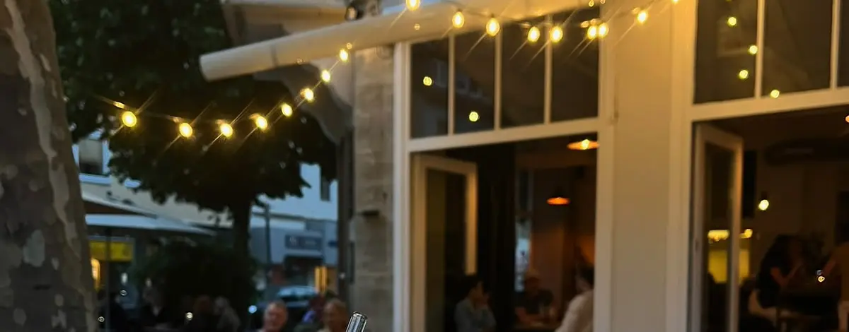 Die Terrasse des Café Heidelberg am Neustädter Markt in Hildesheim am Abend, mit Lichterkette über den Tischen